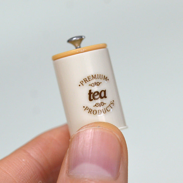 Single 1:6 miniature kitchen storage canister shown between fingers
