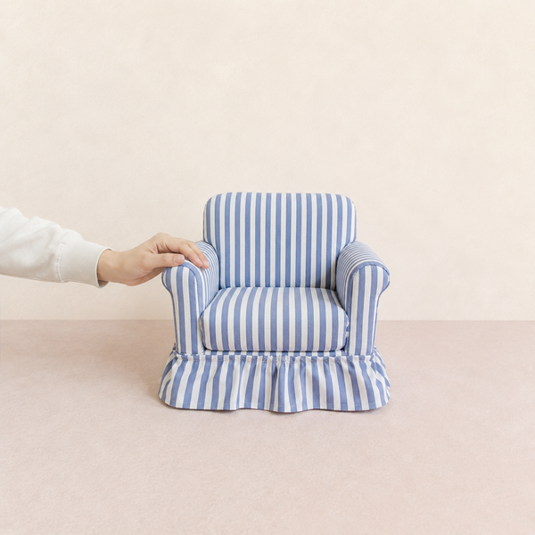Blue striped miniature skirted armchair beside a hand for size reference